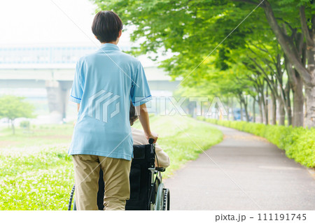 車椅子を押す介護士 111191745