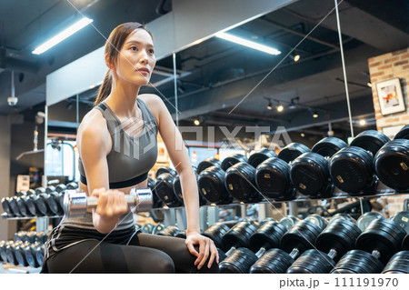 ジムで筋トレをする若い女性 111191970