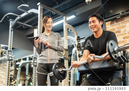 ジムでトレーニングをする男性と女性トレーナー ジムでトレーニングをする男性と女性トレーナー 111191983