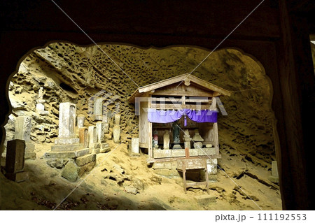 秋の秩父札所32番法性寺の観音堂裏のタフォニ地層の岩窟地蔵 111192553