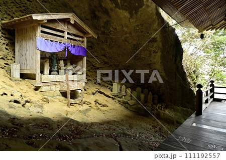 秋の秩父札所32番法性寺の観音堂裏のタフォニ地層の岩窟地蔵 111192557