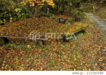 秋の秩父札所32番法性寺境内のイチョウの落ち葉にベンチ 111192589