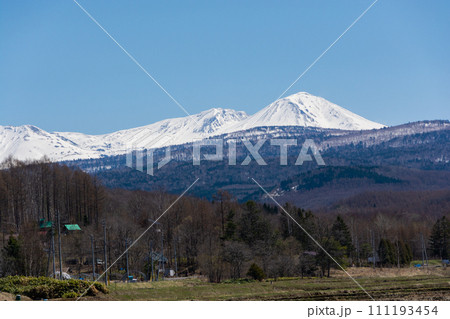 春の晴れた日の水田地帯と冠雪の山並み 大雪山 春の晴れた日の水田地帯と冠雪の山並み 大雪山 111193454