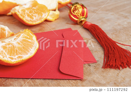 Peal Mandarin oranges and Chinese New Year red envelope. Chinese New Year celebration concept Peal Mandarin oranges and Chinese New Year red envelope. Chinese New Year celebration concept 111197292