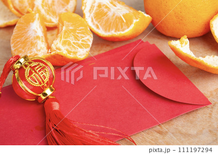Peal Mandarin oranges and Chinese New Year red packet. Chinese New Year celebration concept Peal Mandarin oranges and Chinese New Year red packet. Chinese New Year celebration concept 111197294