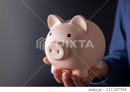 saving money wealth and financial investment concept.businessman holding pink piggy bank in his hand saving money wealth and financial investment concept.businessman holding pink piggy bank in his hand 111197708