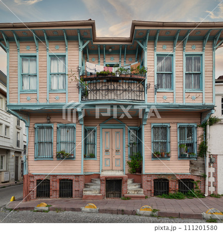 Colorful wooden house in Istanbul's Fatih district. Painted pink and blue with flower-adorned balconies 111201580