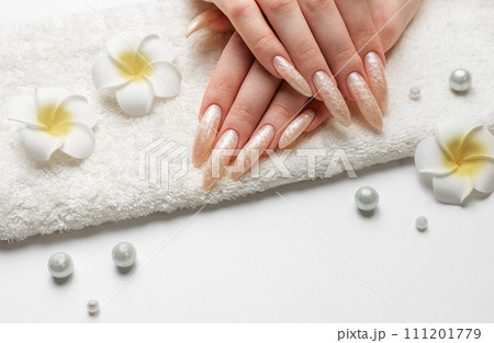 Hand of a young woman with white pearl  manicure 111201779