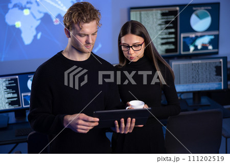 Two professionals in cyber security team working to prevent security threats, find vulnerability and solve incidents Two professionals in cyber security team working to prevent security threats, find vulnerability and solve incidents 111202519