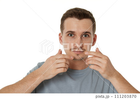 surprised guy looking at camera on white studio background 111203870