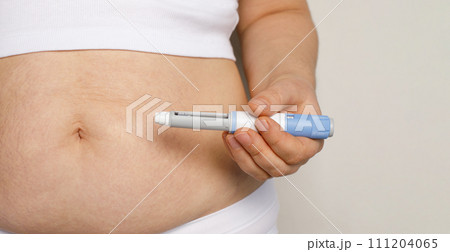 Woman hand with semaglutide injection pen or insulin cartridge pen for diabetics and weight loss. Woman hand with semaglutide injection pen or insulin cartridge pen for diabetics and weight loss. 111204065