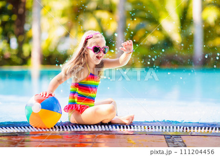 Child in swimming pool with ball. Kids swim. 111204456