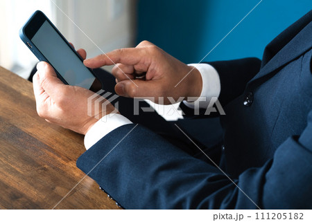 スマートフォンを操作するビジネスマンの手元 スマートフォンを操作するビジネスマンの手元 111205182