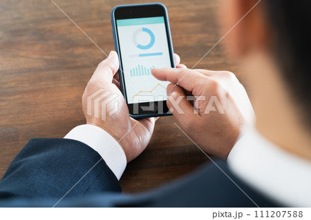 スマートフォンを操作するビジネスマンの手元 スマートフォンを操作するビジネスマンの手元 111207588