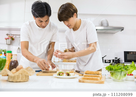 Happy Asian young lgbtq gay couple make sandwich in kitchen 111208099