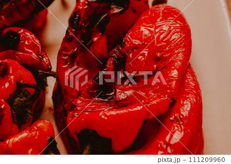 Red roasted kapia paprika on a ceramic plate. 111209960