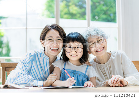 勉強する女の子と見守る家族 勉強する女の子と見守る家族 111210421