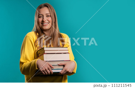 Happy student woman with stack books from library, blue background. Copy space Happy student woman with stack books from library, blue background. Copy space 111211545