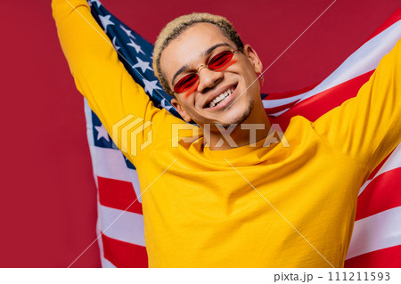 Happy man with national USA flag on red background. American patriot 4th of July Happy man with national USA flag on red background. American patriot 4th of July 111211593