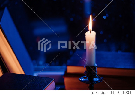 Vintage background. Stack of paper books near rainy window. Bronze candlestick. Vintage background. Stack of paper books near rainy window. Bronze candlestick. 111211901