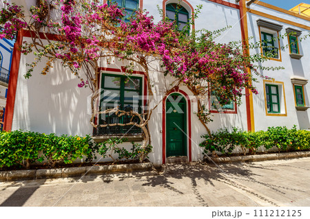 historic center of puerto de mogan with lots of bougainvillea flowers, Canary Island 111212125