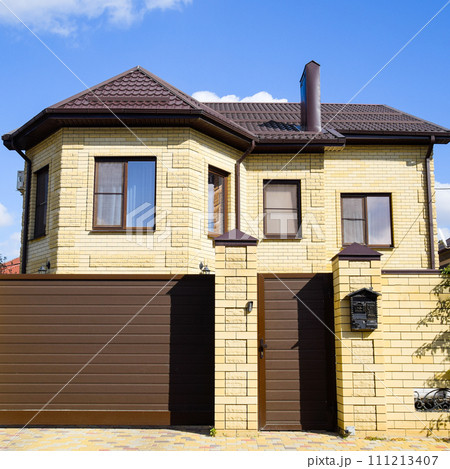 Decorative metal on the roof of a brick house. Fence made of cor Decorative metal on the roof of a brick house. Fence made of cor 111213407