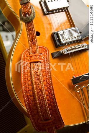 Closeup of Richly Colored Electric Guitar with Intricately Designed Strap Closeup of Richly Colored Electric Guitar with Intricately Designed Strap 111214099