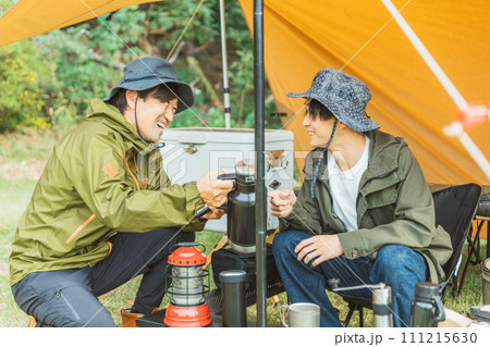 秋冬のキャンプ場でテントを張ってキャンプをする男性キャンパー 秋冬のキャンプ場でテントを張ってキャンプをする男性キャンパー 111215630