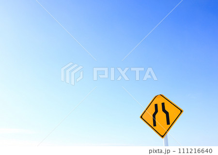 青空とこの先道が狭くなることを知らせる標識 111216640