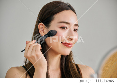 ファンデーションを塗るロングヘアの30代女性 ファンデーションを塗るロングヘアの30代女性 111216965