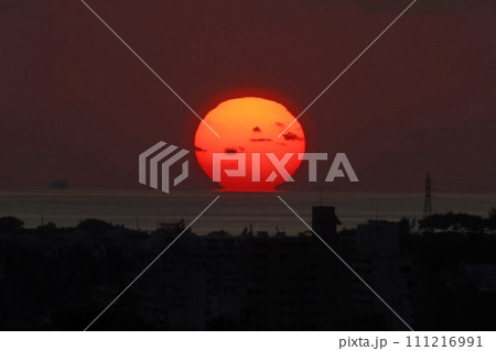 那覇のホテルラウンジから見たダルマ夕日 111216991