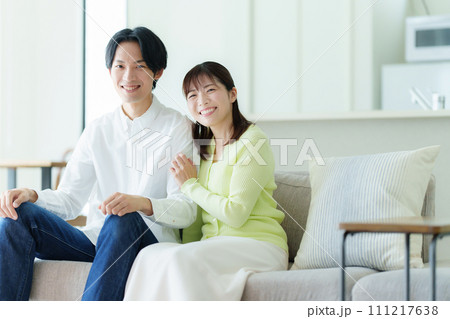 リビングでくつろぐ若い夫婦 リビングでくつろぐ若い夫婦 111217638