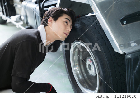 工場で働く男性　車やトラック、タイヤの整備などの自動車整備士（メカニック）製造業のイメージの横顔 111219020