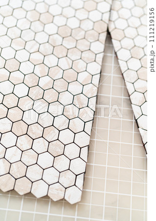 In the process of mounting peel and stick mosaic tiles onto a foam board, perfect for enhancing a food photography studio's aesthetic. In the process of mounting peel and stick mosaic tiles onto a foam board, perfect for enhancing a food photography studio's aesthetic. 111219156