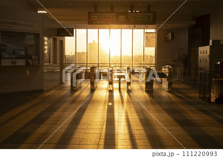 朝日が差し込む駅の改札口 111220993