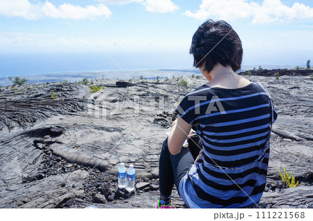 岩の上で絶景を前にしてうつむく女性 岩の上で絶景を前にしてうつむく女性 111221568