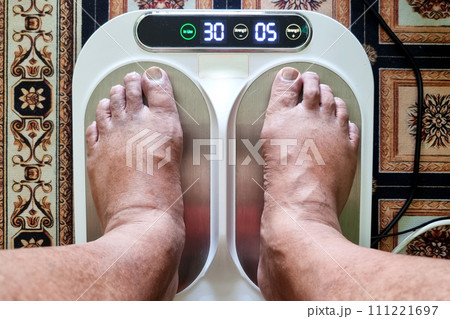 Closeup of person feet receiving magnetic therapy from electricity powered geomagnetic device, promising general well being benefits Closeup of person feet receiving magnetic therapy from electricity powered geomagnetic device, promising general well being benefits 111221697