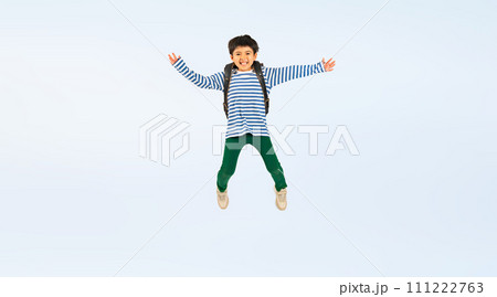 ランドセルを背負って笑顔でジャンプする小学生の男の子 111222763