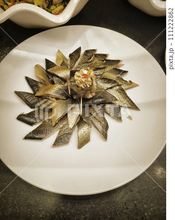 Smoked herring slices on a white plate in a restaurant 111222862