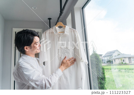 洗濯物を干す男性(家事・主夫・洗剤・柔軟剤・漂白) 洗濯物を干す男性(家事・主夫・洗剤・柔軟剤・漂白) 111223327