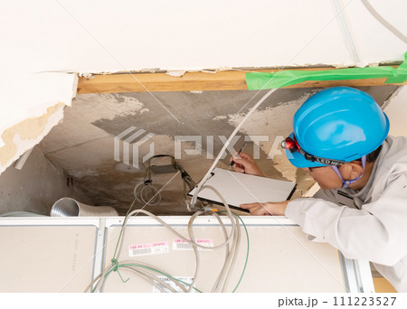 リフォーム工事　天井を調査確認する作業員 111223527