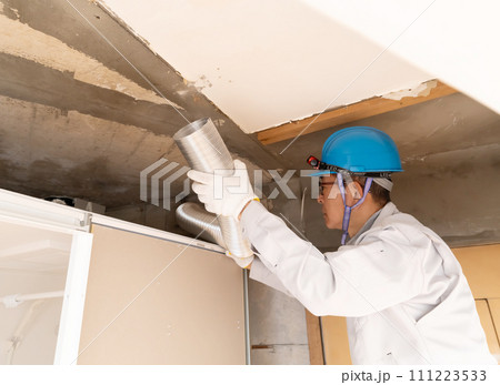 リフォーム工事　換気ダクトを設置する作業員 111223533