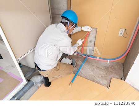 リフォーム工事 給水管・給湯管を点検する作業員 リフォーム工事 給水管・給湯管を点検する作業員 111223540