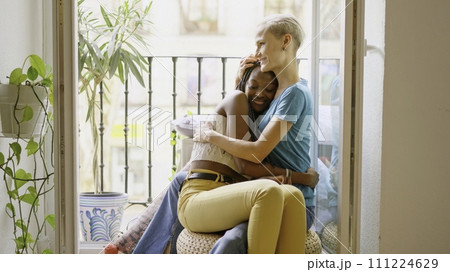 Lesbian lovers embracing sitting on the balcony Lesbian lovers embracing sitting on the balcony 111224629