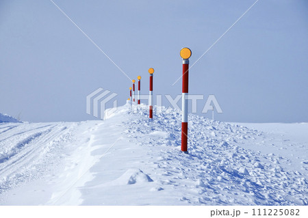 冬の圧雪道路とスノーポール 111225082