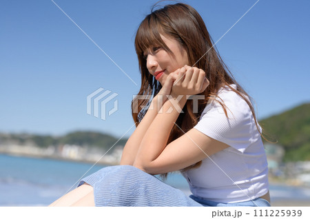 晴れの日の砂浜にたたずむ女性 晴れの日の砂浜にたたずむ女性 111225939