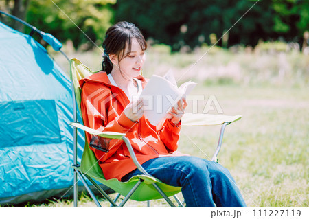テントの前で本を読む女性 111227119