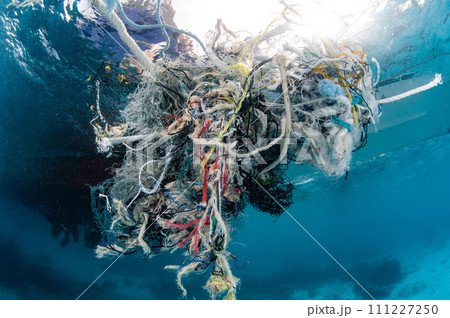 Abandoned fishing net and plastic garbage in the sea 111227250