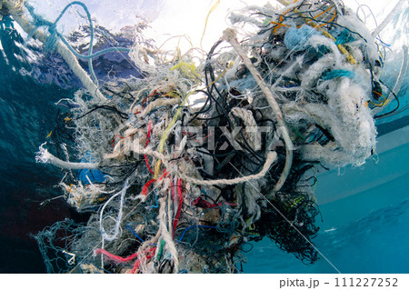 Abandoned fishing net and plastic garbage in the sea 111227252