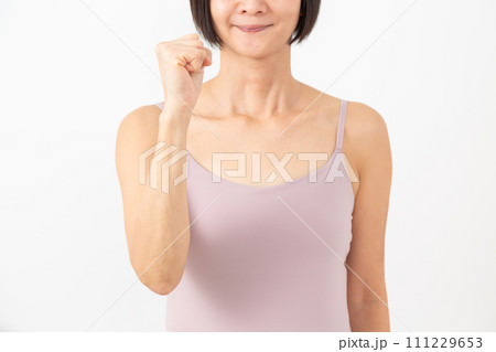 ガッツポーズをするキャミソール姿のミドル女性 ガッツポーズをするキャミソール姿のミドル女性 111229653